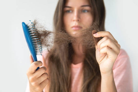 Woman looking at loose hair from a brush